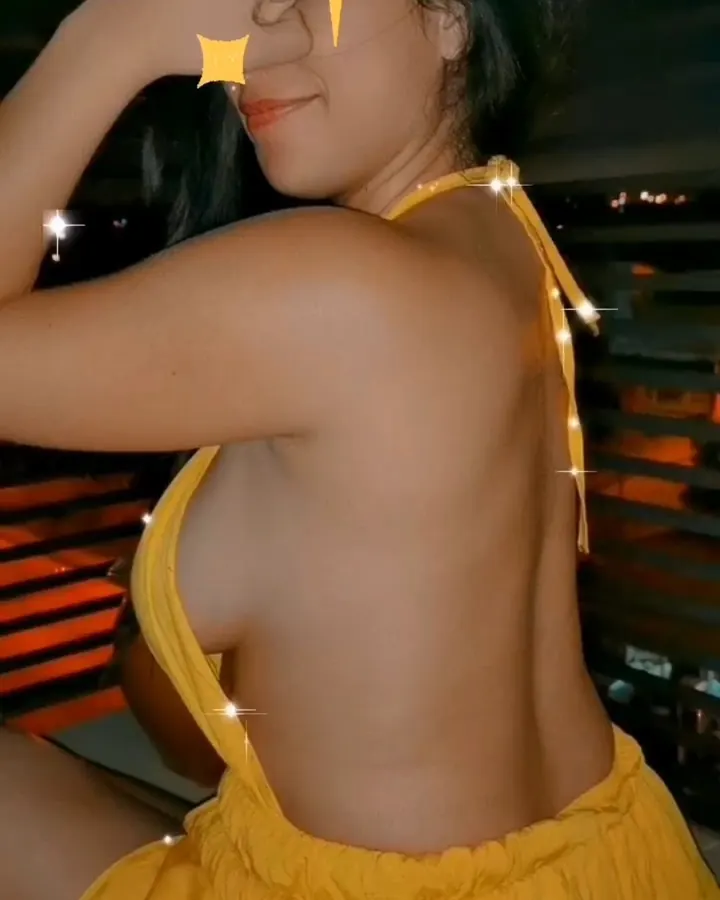 Femme en robe jaune, dos tourné, main sur les yeux, filtres étoiles sur l'image, regardant vers le bas.
