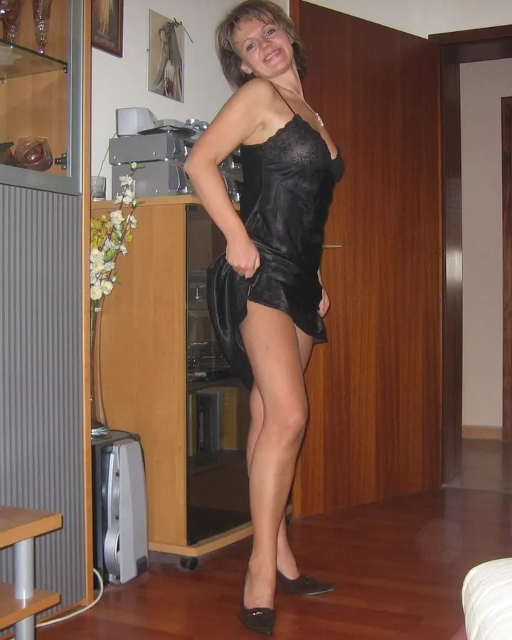 Femme blonde en robe bleue, assise sur un fauteuil bleu, dans un bar.