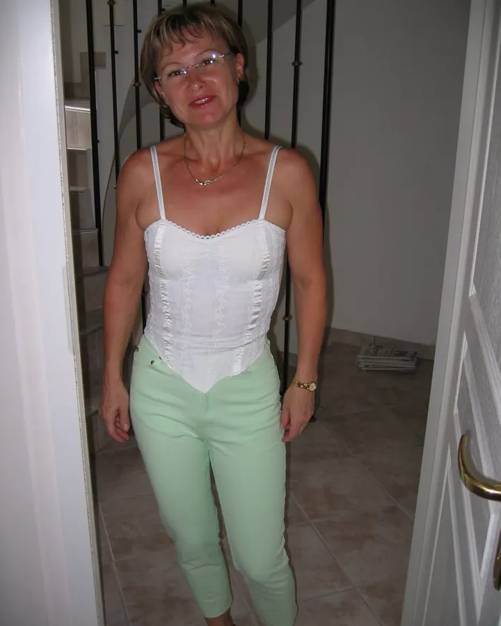 Femme européenne aux cheveux blonds, en haut noir, regardant l'appareil avec un air pensif.